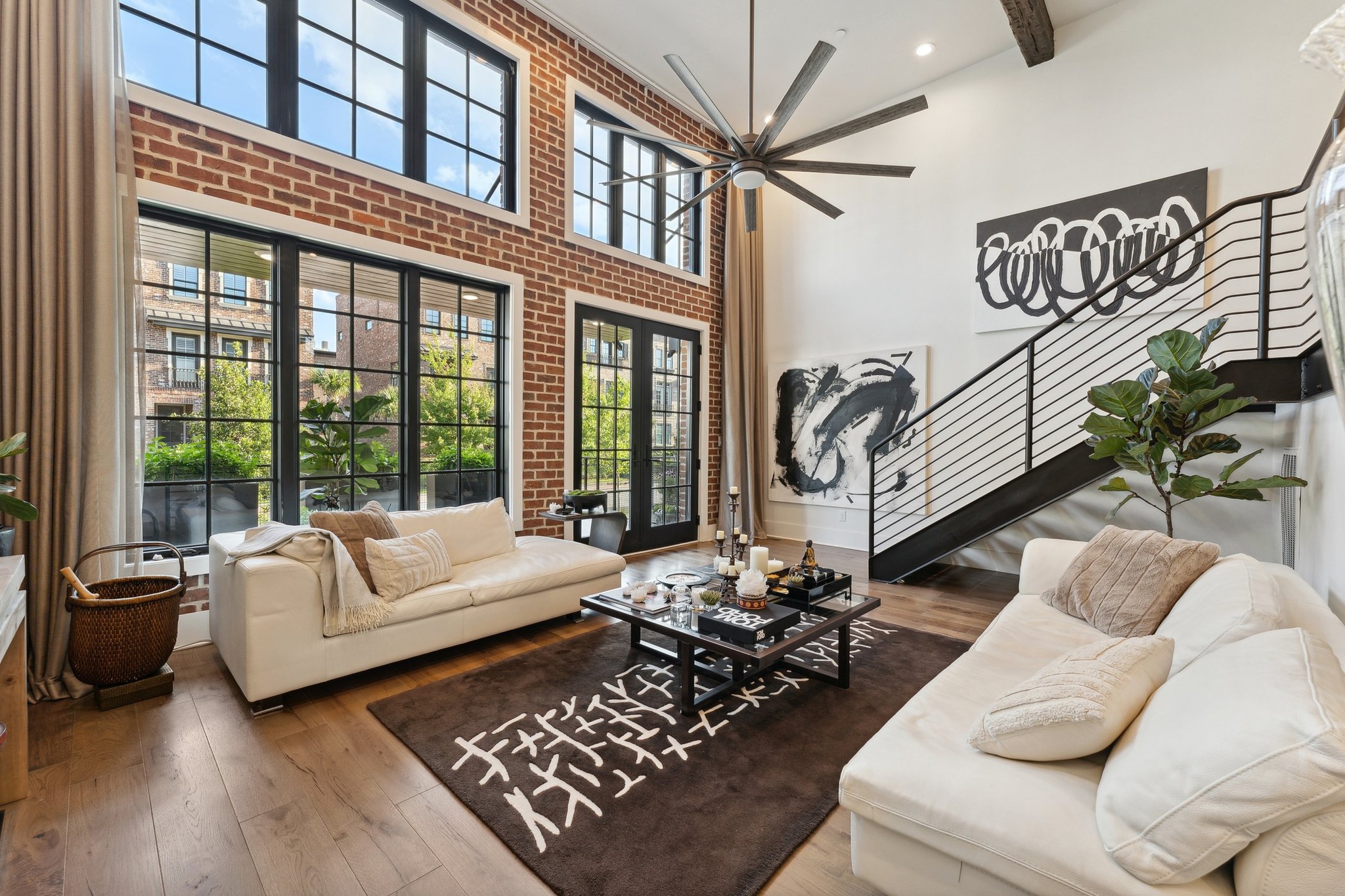 a living room with a brick wall and a large window - mastering real estate photography